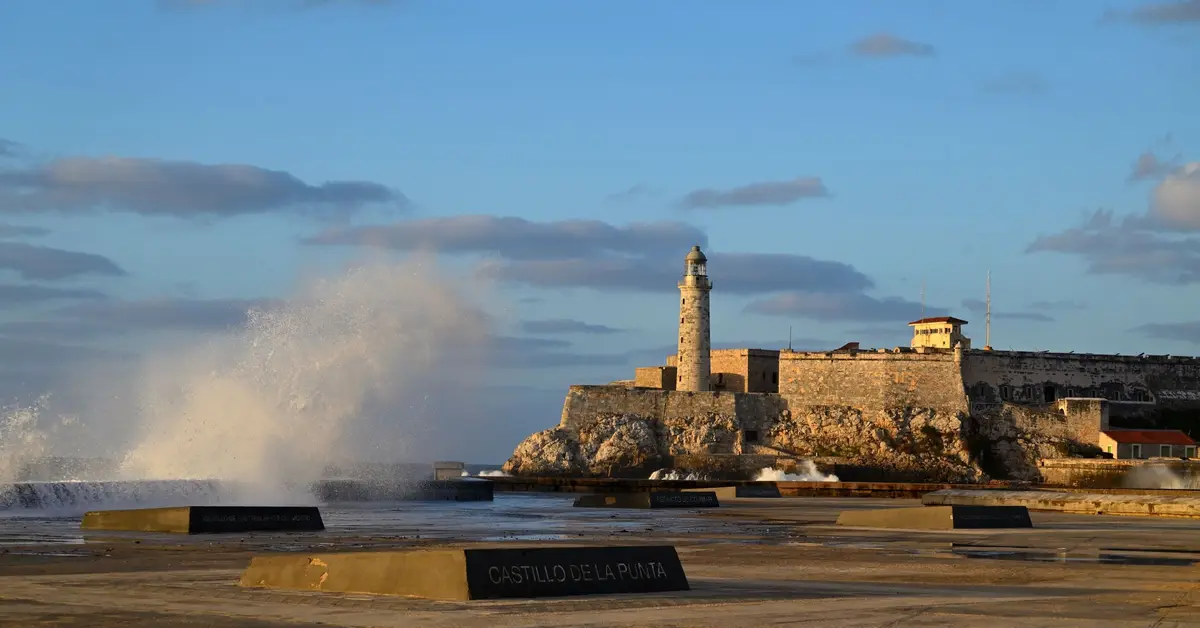 Waves against the Malecón with El Morro at sunset